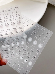 Detailed close-up of cute cartoon cat facial expressions on semi-transparent nail art stickers