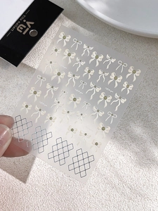 Detailed view of translucent nail art stickers featuring elegant cream bows and grid patterns