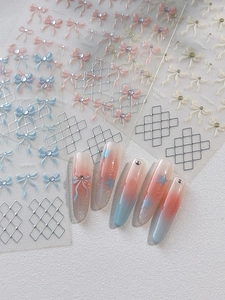 Macro shot of 3D double-layered bow nail art stickers with pink and blue lattice patterns