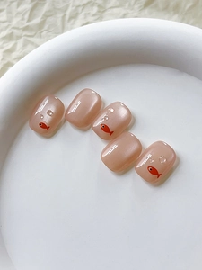 Detail of nude pink press-on nails with 3D water droplets and orange fish pattern