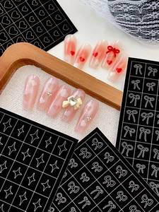 Detail of pink and red gradient press-on nails with 3D bows and heart stickers