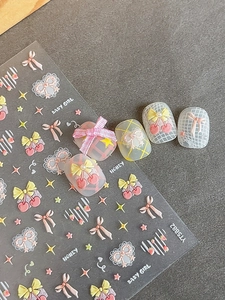 Detailed view of 3D embossed nail stickers with cherry, bow, and heart designs
