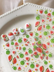 Detailed summer watermelon nail stickers and application on white false nails in a tray