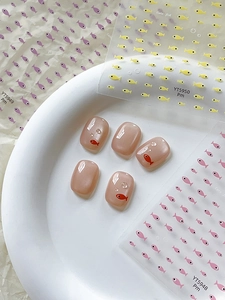 Close-up of pink cat eye fake nails with red fish patterns and 3D water drops