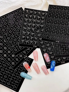 Detail of star and bow nail art stickers showing various black and white patterns