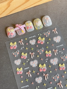 Detailed view of 3D embossed nail stickers with cherry, bow, and star patterns