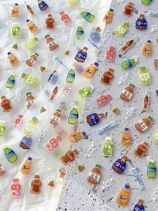 Macro shot of 3D resin summer drink stickers with embossed soda and fruit bottle designs
