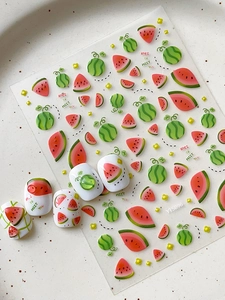Close-up of summer watermelon nail stickers and application on white nail tips