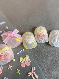 Detail of 3D embossed nail stickers with cherry, bow, and lace heart designs