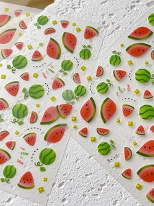 Macro detail of summer watermelon nail stickers with red slices and green fruit patterns