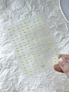 Detail of yellow cute fish nail stickers with minimalist design and transparent backing