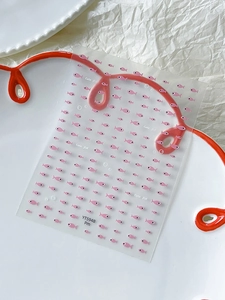 Detail view of pink cute fish nail art stickers on a white textured background