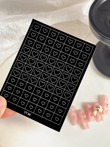 Detail showing white hollow heart nail decals YT94 on pink manicured nails with 3D bows
