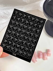 Close-up of white bow nail art stickers YT96 with application on gradient pink nails