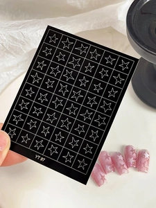 Detailed view of YT 97 black and white star nail stickers on a pink glitter manicure