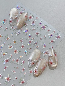 Macro shot of 5-petal flower nail stickers with iridescent shell finish on pink manicures