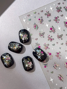 Detaillierte Nahaufnahme schwarzer Stern-Nägel mit bunten Glitzer-Pailletten-Aufklebern