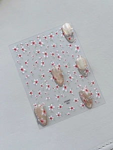 Macro detail of floral nail art stickers with pink shell finish and green leaf motifs