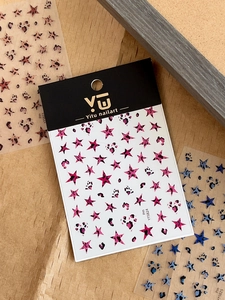 Detailed view of leopard print star and heart nail stickers in pink, blue, and brown