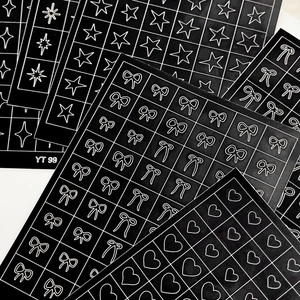 Minimalist black and white nail stickers featuring bows, stars, and hearts patterns