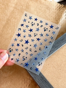 Detail shot of leopard print star nail stickers with blue and black patterns on transparent film