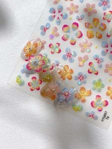 Detailed close-up of colorful 5-petal flower nail art stickers with 3D pearl accents