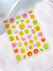 Detailed view of 3D fruit slice nail stickers with lemon and kiwi patterns for DIY art
