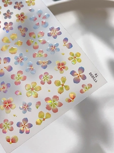 Macro detail of 3D iridescent floral nail stickers with pink and blue gradient petals