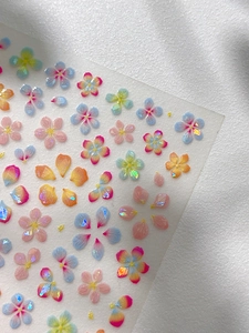 Macro shot of iridescent five-petal flower nail stickers with shell luster and aurora finish