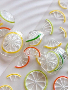 Macro view of 3D lemon and citrus resin nail art stickers with relief texture
