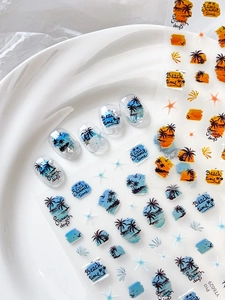 Close-up of summer beach nail stickers featuring palm trees and sunset on white tray