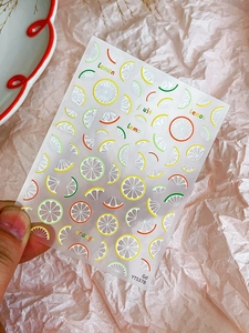 Detailed macro view of semi-transparent summer fruit nail art stickers with lemon designs
