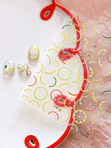 Close-up of summer fruit nail art stickers featuring lemon and orange patterns