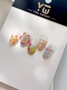 Detailed macro of 3D shell flower nail stickers with pearls and glitter gradient