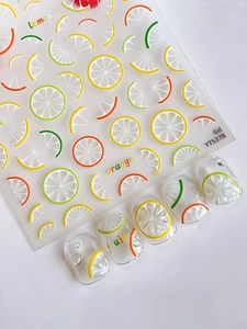 Detail showing translucent lemon and orange nail stickers with fruit slice patterns