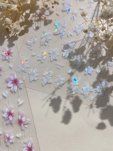 Detail of 3D aurora flower and butterfly nail stickers with iridescent laser metallic finish