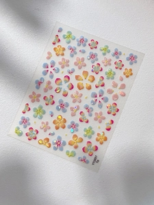 Detail of colorful shell-luster flower nail stickers with holographic laser effects