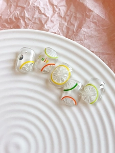 Macro detail of transparent resin fruit charms for summer nail art and DIY jewelry