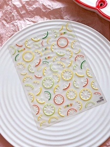 Close-up of lemon and citrus fruit nail art stickers with YT5378 design on a white plate