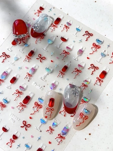 Macro detail of embossed nail art stickers featuring wine glasses and bowknots