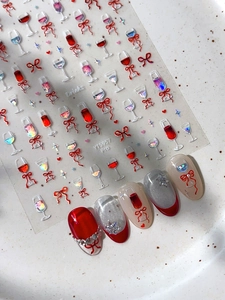 Detail of red wine glass and bow nail stickers showing 3D effects on finished nails