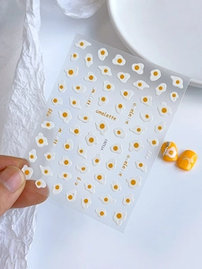 Macro detail of poached egg nail stickers with omelette patterns and white protein textures