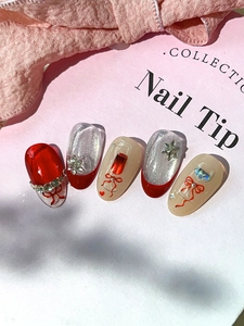 Close-up of red and silver glitter nail stickers with wine glass and bowknot designs