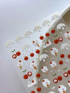 Detailed macro view of 3D embossed dog and cherry nail art stickers with relief texture