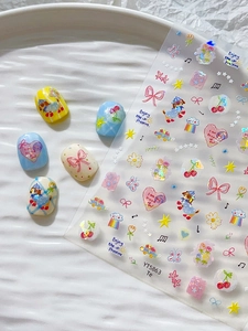 Detail of colorful bow and heart nail stickers with laser glitter effect on nail art