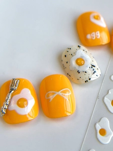 Macro shot of 3D poached egg nail art with glossy finish and cute fork charm details