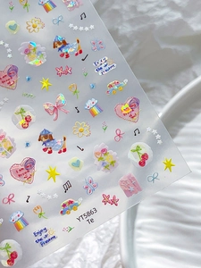 Detailed close-up of cute holographic nail art stickers with heart and bow patterns