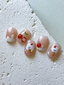 Detail of cute dog and cherry nail art stickers on pink translucent press-on nails