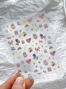 Close-up of shell luster nail art stickers with colorful bow and heart cartoon designs