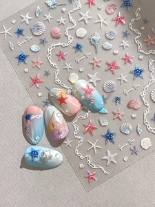 Detail showing 3D ocean-themed starfish shell nail stickers with pearls and glossy finish